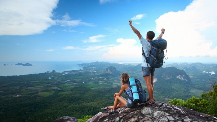 Couple hiking on a mountain overlooking the ocean