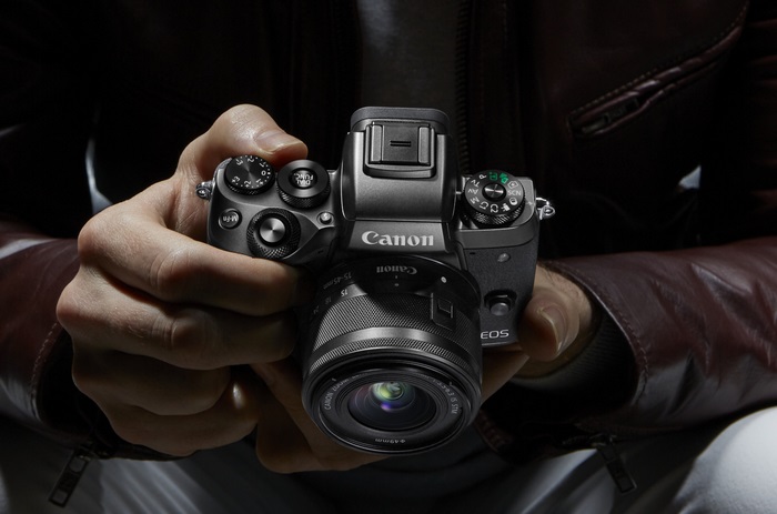 Canon EOS M5 camera held by hands