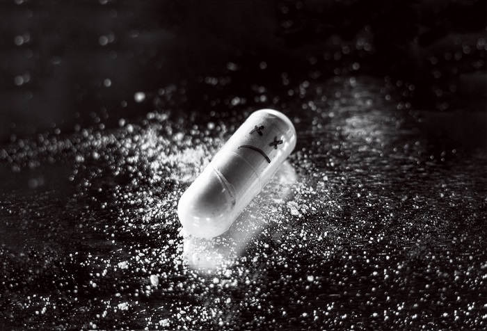 Pill with sad face and powder