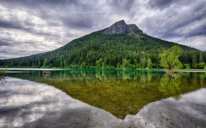 Mountain reflected in a lake with cloudy sky