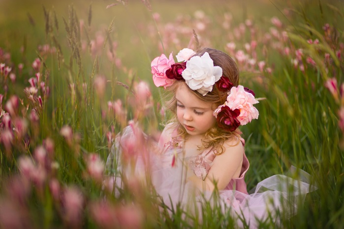Cute girl with flower crown in field