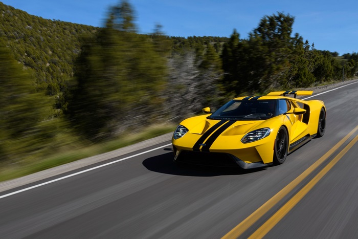 Yellow Ford GT with black stripes on a road