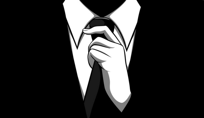 Man in black suit adjusting tie