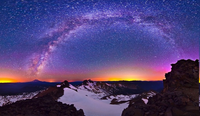 Milky Way over snowy mountain peaks at night