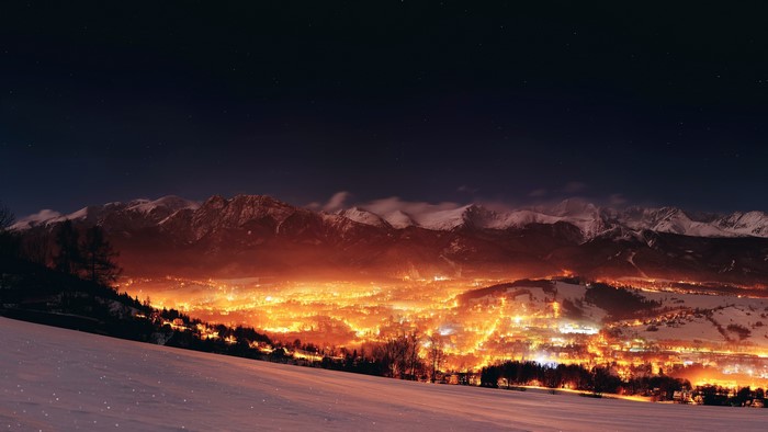 Night landscape of mountains and a glowing town in Poland