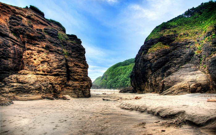 Rocky cliffs and sandy beach under a blue sky
