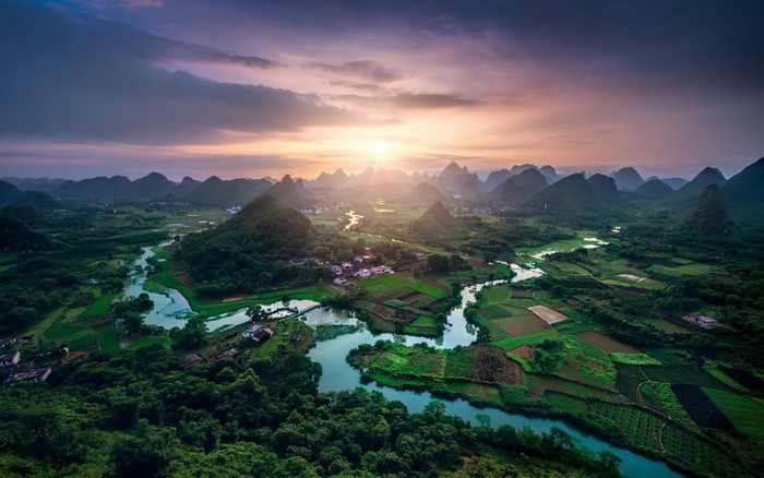 Karst landscape with river and fields at sunset in China
