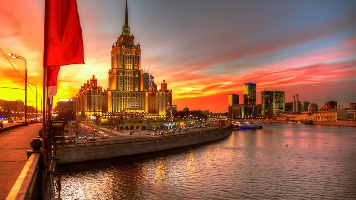 Moscow cityscape with Stalinist skyscraper and river at sunset