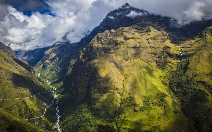 Mountain valley with river and road in clouds