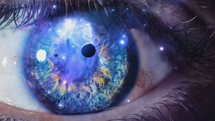 Eye reflecting a galaxy with planets