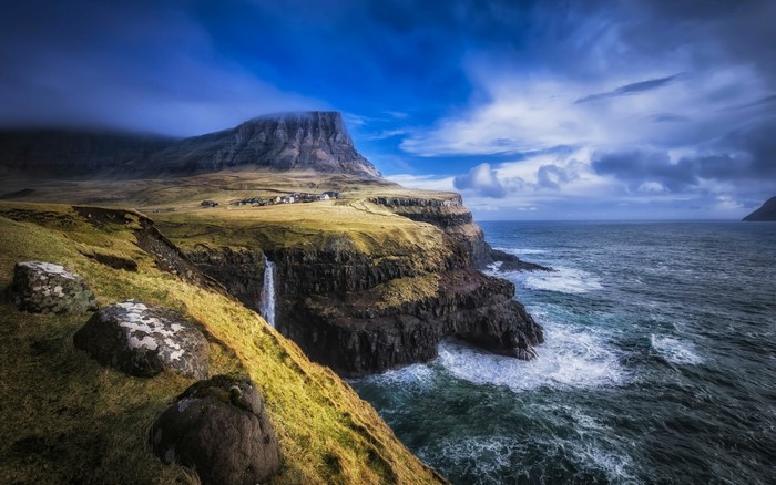 Waterfall cliffs and village in the Faroe Islands