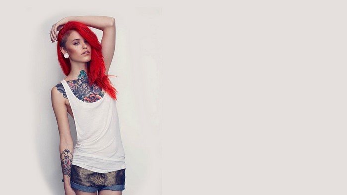 Woman with red hair and chest tattoos