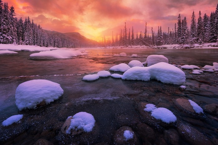 Winter sunrise over a snowy river in Banff National Park, Canada