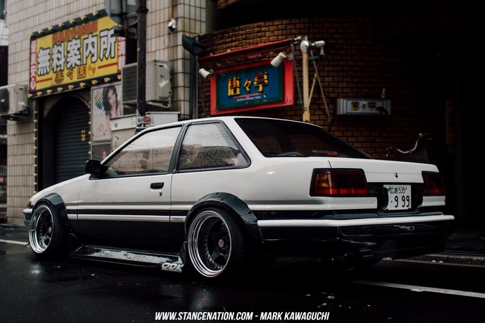 Toyota AE86 parked on a wet street in Japan