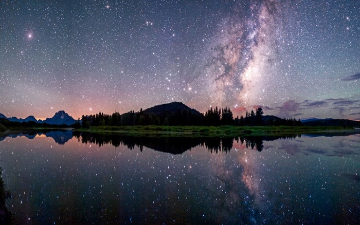 Milky Way over mountains reflected in a lake