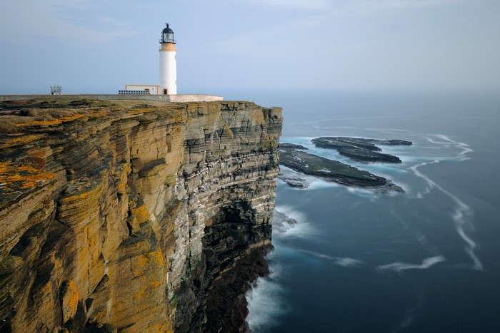 Lighthouse on a dramatic sea cliff overlooking the ocean