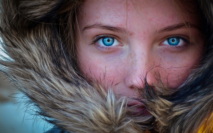 Close-up portrait of a woman with blue eyes and freckles
