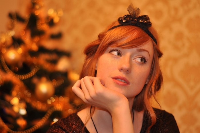 Redhead woman with hair bow looking away