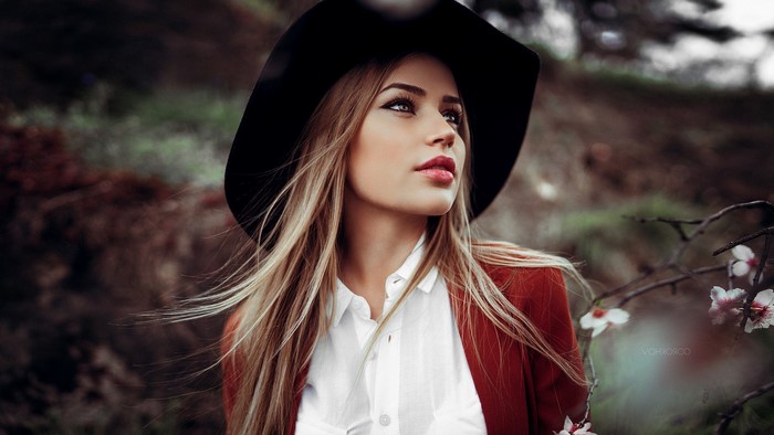 Woman with blonde hair wearing a hat and red jacket