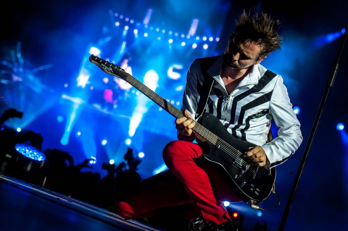 Matthew Bellamy from Muse playing guitar on stage