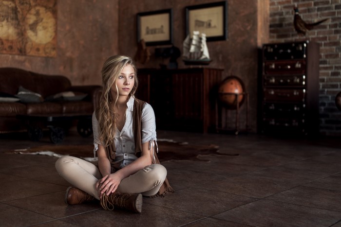 Woman with long blonde hair sitting on the floor