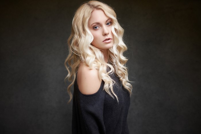 Woman with blonde wavy hair in a black top