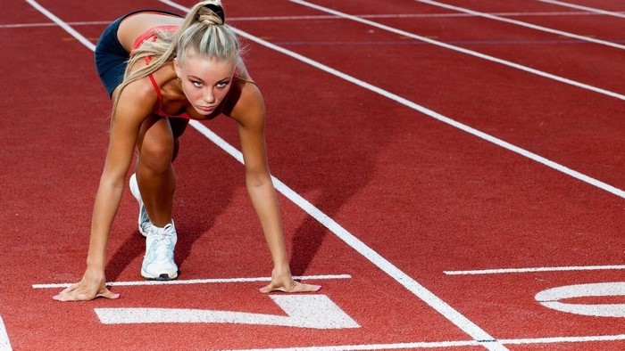 Woman in starting position on a running track