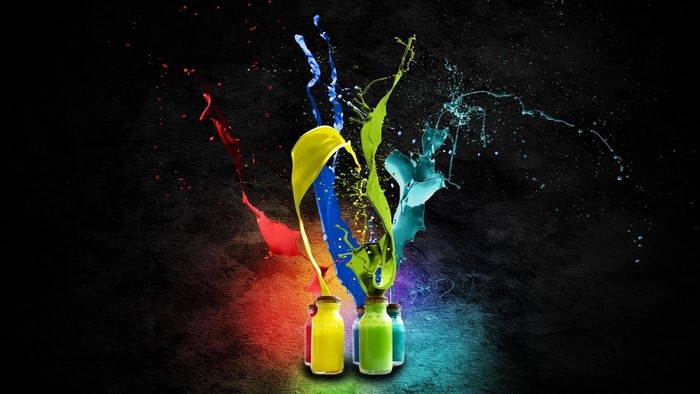 Colorful paint splashes from bottles on black background