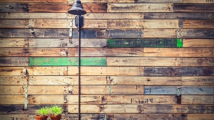 Wooden wall with lamp and potted plants