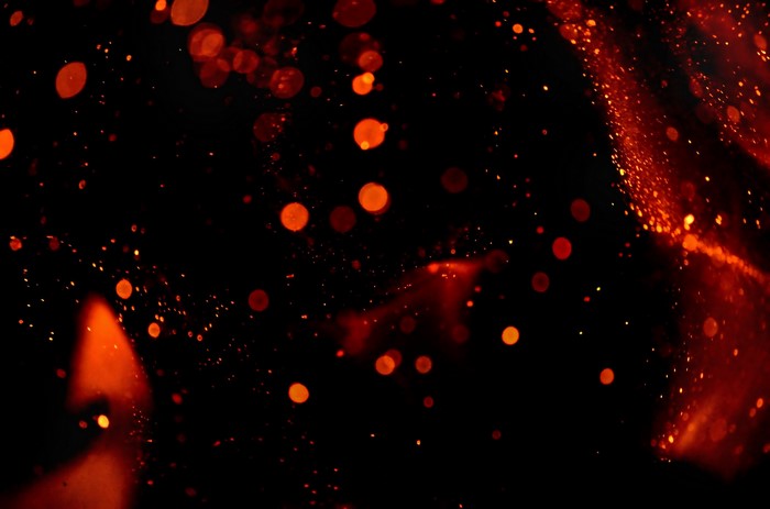 Red bokeh and dust particles on black background