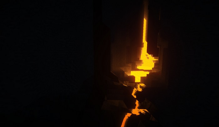 Minecraft lava flowing through a dark cave