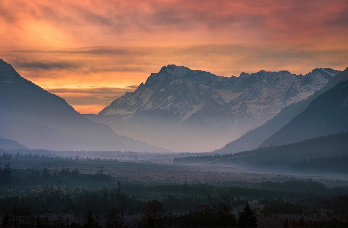 Misty mountain valley at sunset with pink sky