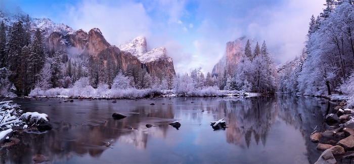 Winter landscape of Yosemite National Park with snow-covered mountains and river