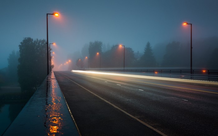 Long exposure of a foggy road with streetlights at night