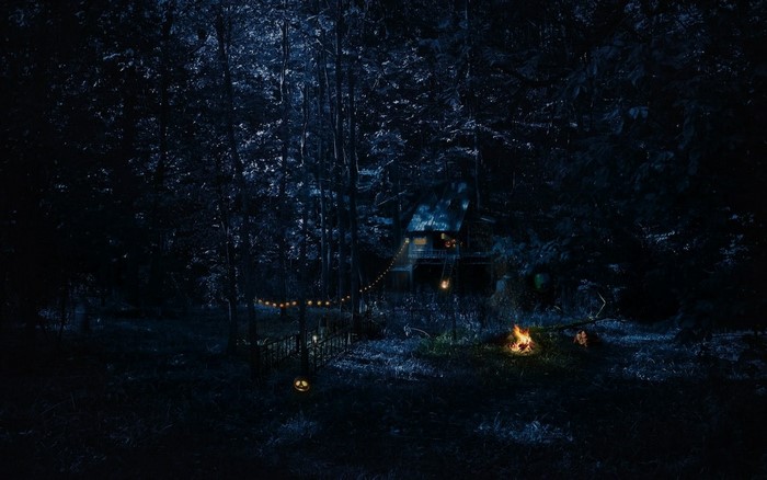 Secluded Cabin at Night with Campfire Glow