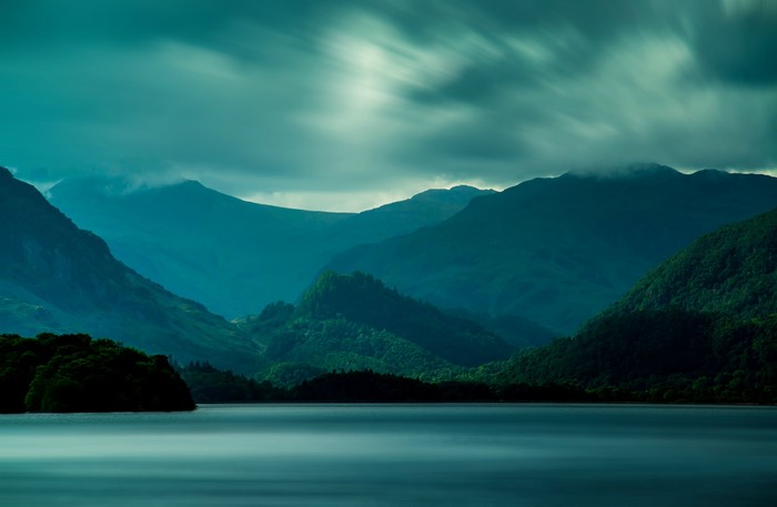 Misty mountains over a lake at dusk