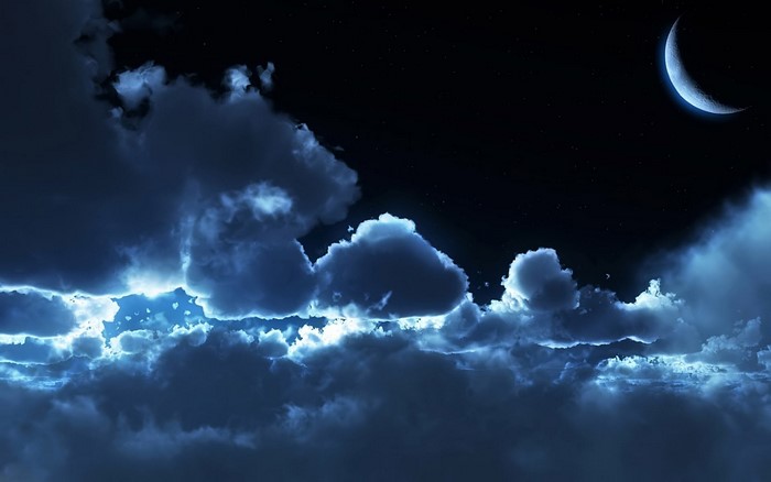 Crescent moon in a cloudy night sky