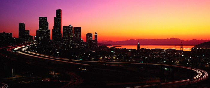 Seattle cityscape at sunset with light trails on highway