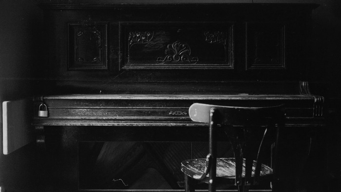 Old piano with a chair in front