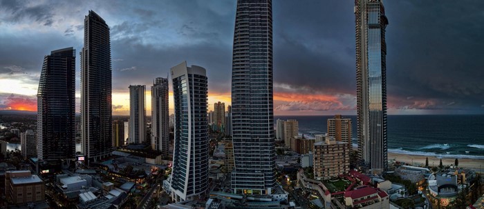 Cityscape with skyscrapers at sunset over the ocean