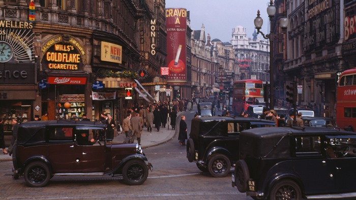 Vintage London street with classic cars and advertisements