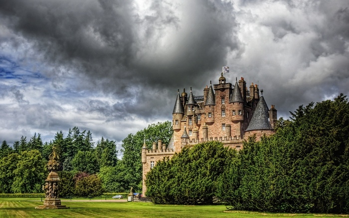 Castle surrounded by trees under a cloudy sky