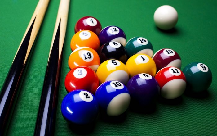 Billiard balls and cues on a pool table