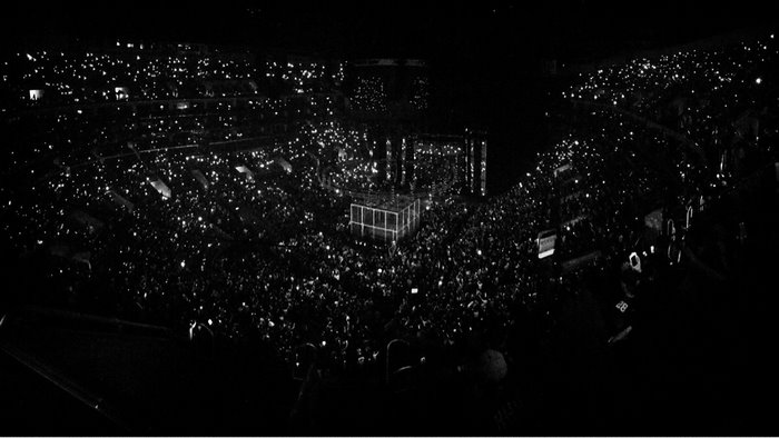 Wrestling event in a stadium with a crowd holding lights