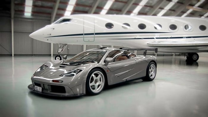McLaren F1 car and private jet in a hangar