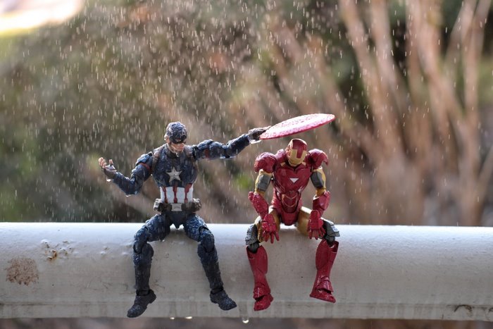 Captain America and Iron Man toys in the rain