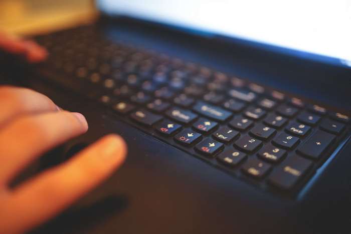 Hand typing on a laptop keyboard 4K