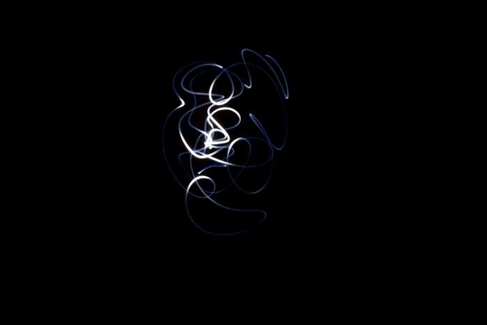 Abstract light painting with white and blue lines on black background
