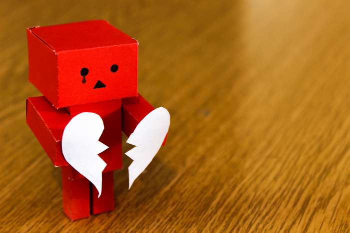 Red robot holding a broken heart