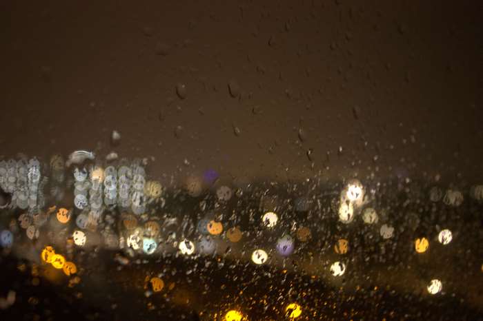 Rainy night city lights through a window 4K
